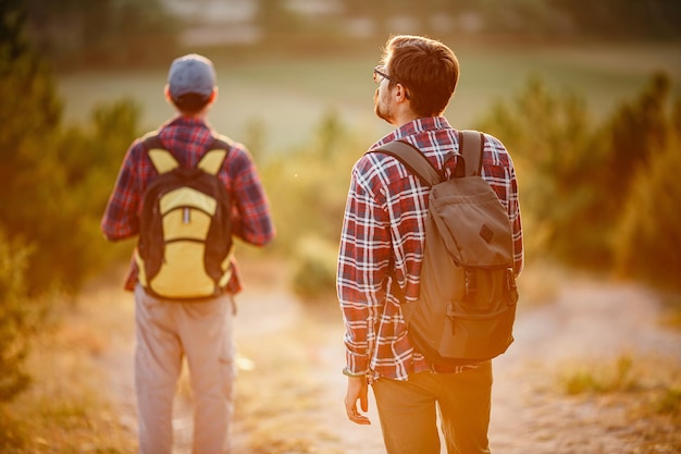 Zwei Wanderer genießen im Sommer einen Spaziergang in der Natur bei Sonnenuntergang