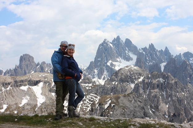 Zwei Wanderer stehen auf einem Felsen und schauen in die Kamera