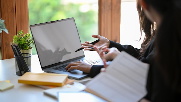 Zwei weibliche Finanzangestellte diskutieren und analysieren gemeinsam ihren Auftrag im Büro.