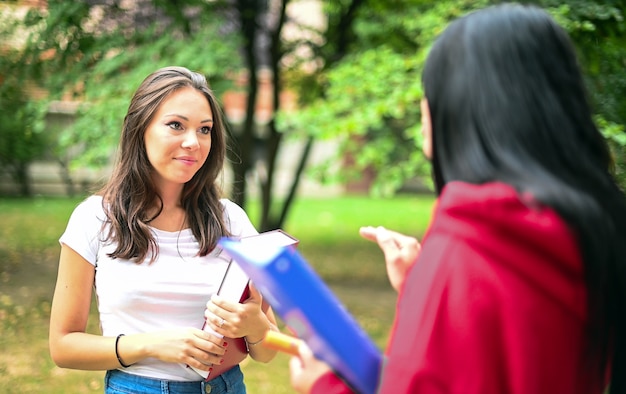 Zwei weibliche Schulkameraden, die in einem College-Hof sprechen