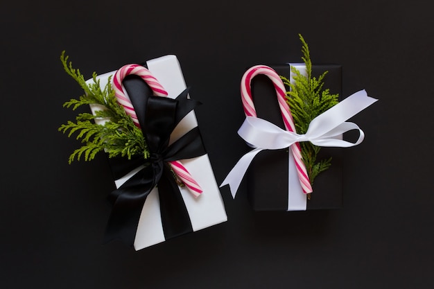 Zwei Weihnachtsgeschenke mit Zuckerstangen auf schwarzem backgounds