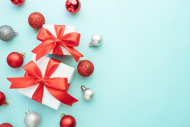 Zwei weiße Geschenkboxen mit roten und silbernen Verzierungen auf blauem Hintergrund. Weihnachtshintergrund. Flache Lage, Draufsicht, Kopierraum.