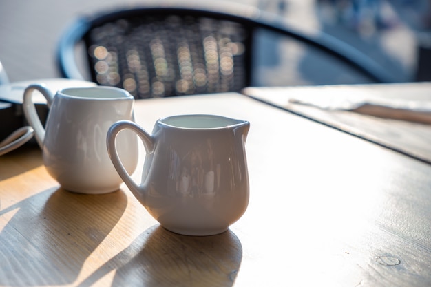 Zwei weiße Tasse Kaffees auf einer Tabelle des Cafés im Freien.