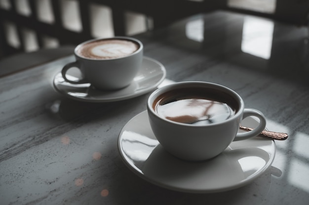 Zwei weiße Tassen heißen Kaffee auf dem Tisch