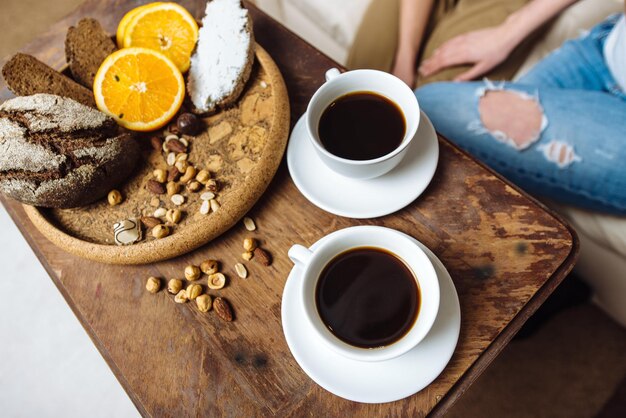 Zwei weiße Tassen mit Espresso auf Holztisch