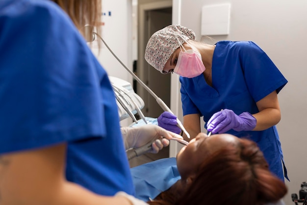 Zwei Zahnärztinnen behandeln einen Patienten in der Zahnklinik