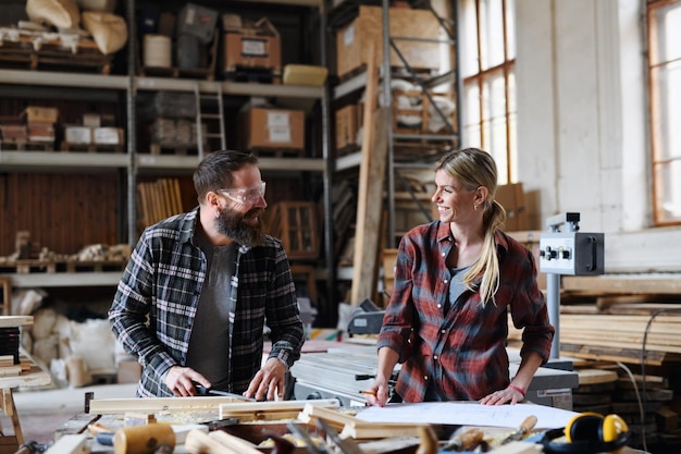 Foto zwei zimmerleute, ein mann und eine frau, sprechen über die gestaltung von produkten.