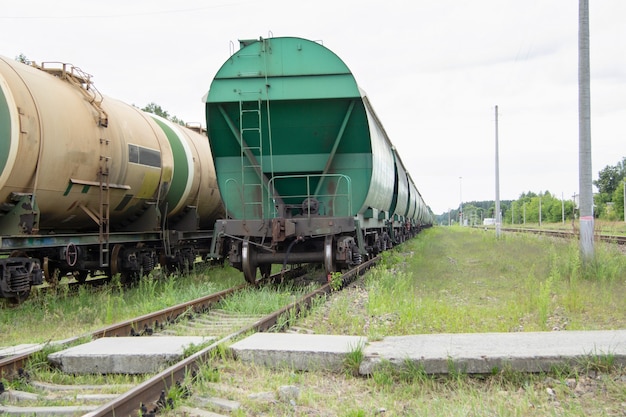 Zwei Züge mit Waggons stehen auf dem Bahnübergang Güterwagen und Kesselwagen