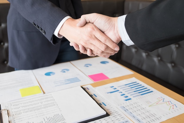 Zwei zuversichtlich Geschäftsmann Händeschütteln während einer Sitzung im Büro, Erfolg, Handel, Gruß und Partner-Konzept.