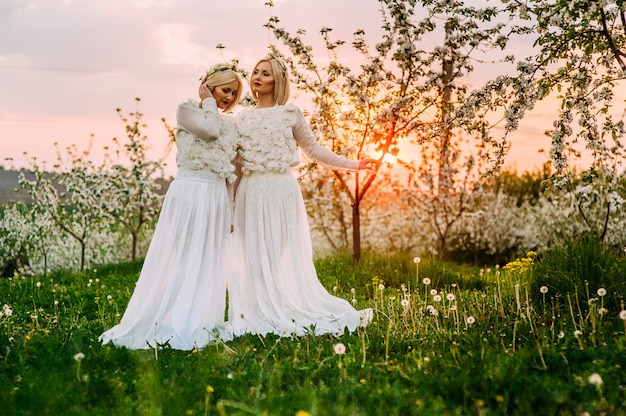 zwei Zwillingsschwestern in einem Kirschgarten