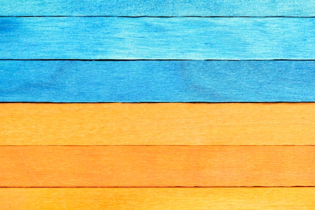Zweifarbiger Hintergrund aus blauen und orangefarbenen Holzbohlen