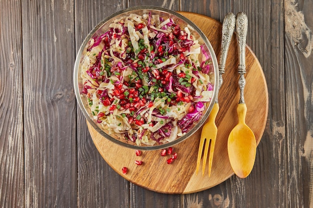 Zweifarbiger Kohlsalat mit Granatapfelkernen und gesalzenen Nüssen. Französische Gourmetküche. Flach legen