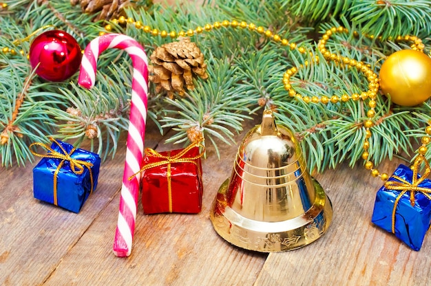 Zweige eines Weihnachtsbaums mit Ornamenten und Süßigkeiten auf den Brettern