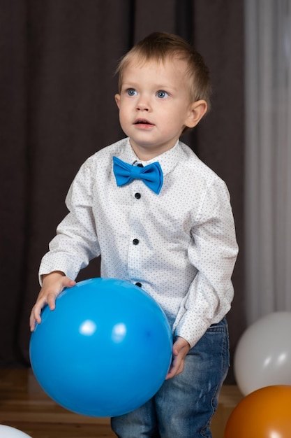 Foto zweijähriges kleinkind spielt mit einem blauen ballon