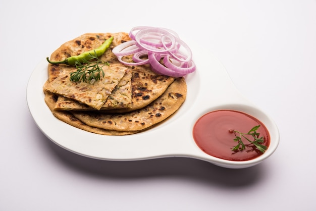 Zwiebel-Parotha oder Pyaj-Parantha oder Kanda-Paratha serviert mit Tomatenketchup und grünem Chutney.