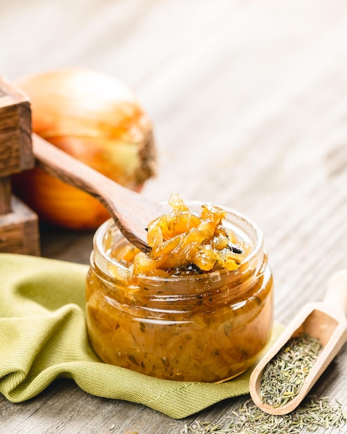 Zwiebelmarmelade in einem Glasgefäß auf einem Holztisch