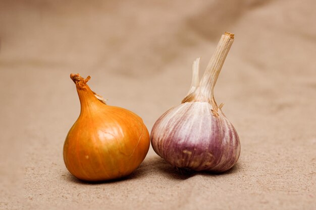 Zwiebeln und Knoblauch auf einem Hintergrund aus Sackleinen