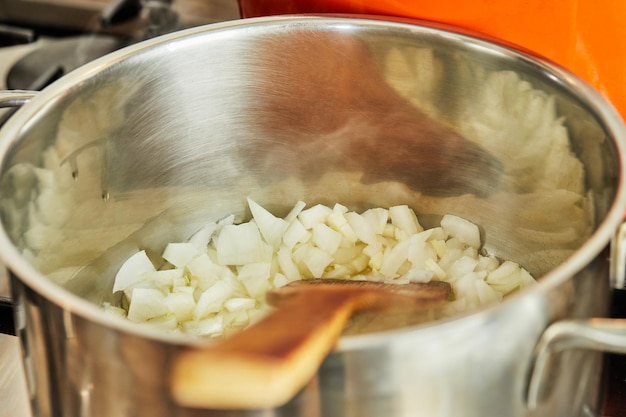 Zwiebeln werden im Topf gebraten, um ein Rezept aus dem Internet zuzubereiten