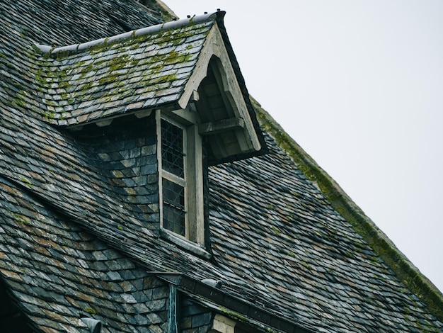 Zwischen Dachziegeln hervorstehende Fenster, mittelalterliche Hausdächer