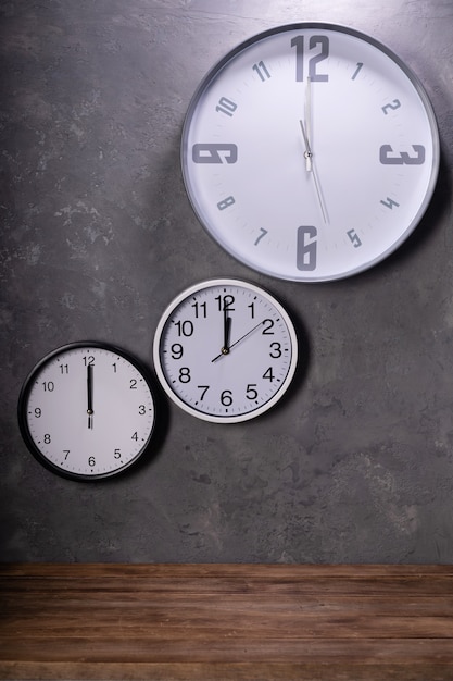 Zwölf Uhr an der Wanduhr mit Betonhintergrund, graue Texturoberfläche