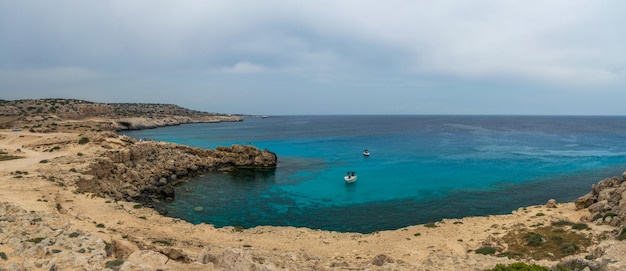 Foto zypern, kap cavo greco. touristen fuhren mit einem motorboot zum schwimmen in die blaue lagune