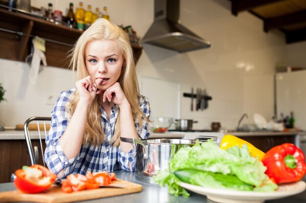 1 person blonde vegetables contemplating counter