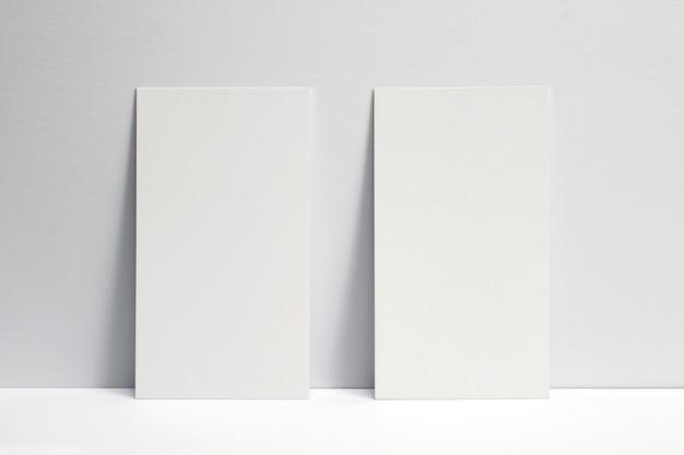 2 blank business cards locked on white wall, 3.5 x 2 inches size