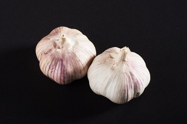 2 fresh garlic bulbs on a black