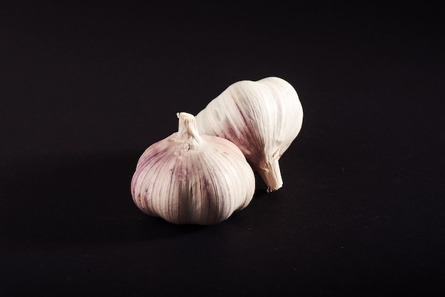 2 fresh garlic bulbs on a black