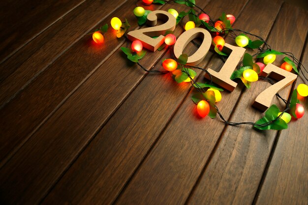 Free Photo 2017 happy new year, wooden figures and flashing lights on the retro desktop