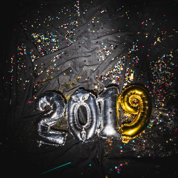 2019 balloons on dark fabric with confetti