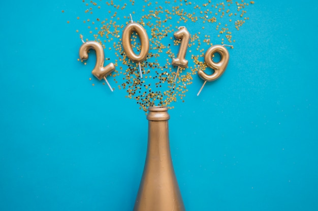 2019 inscription from candles with bottle on table 