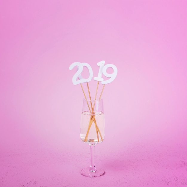 Free photo 2019 inscription on sticks in champagne glass