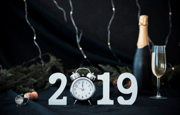 2019 inscription with clock and bottle on table