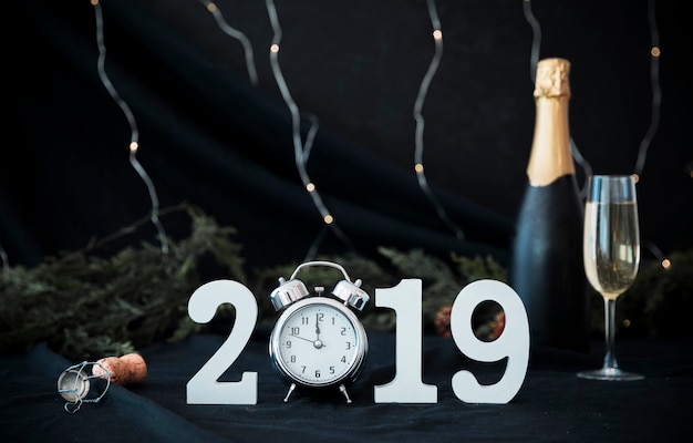 2019 inscription with clock and bottle on table