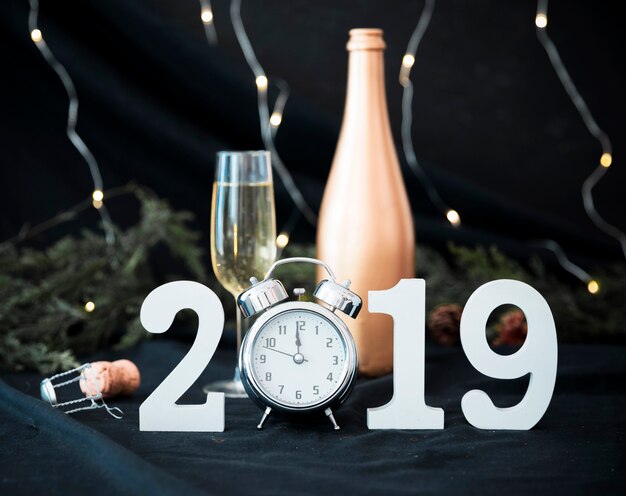 2019 inscription with clock and glass on table