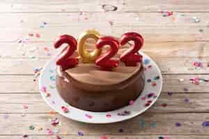 Free photo 2022 cake and ornaments on wooden table