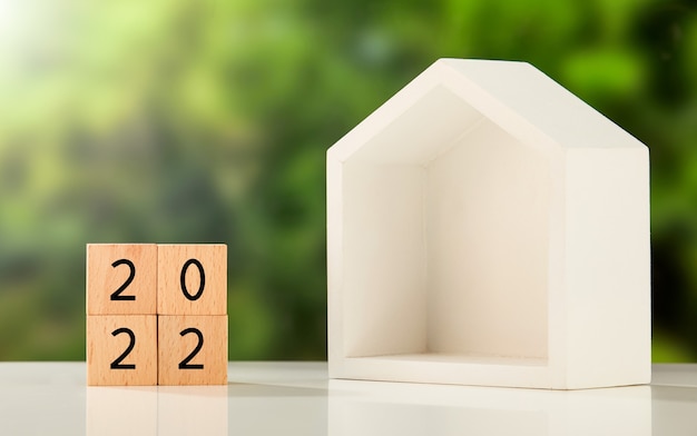 '2022' written on wooden cubes and a box house on a table