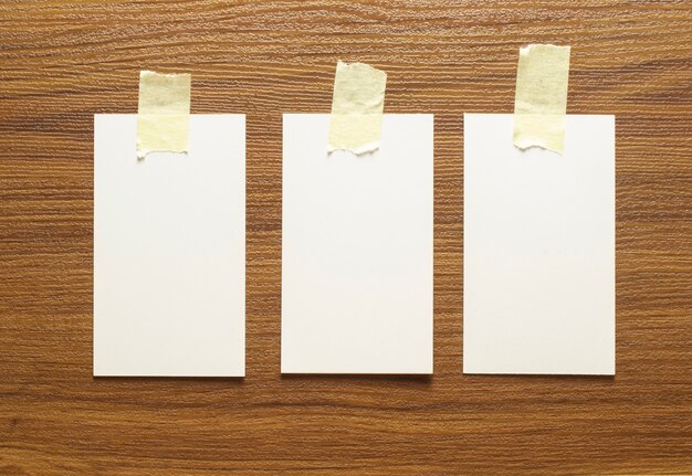 3 blank business cards glued with yellow tape on a wooden surface, 3.5 x 2 inches size