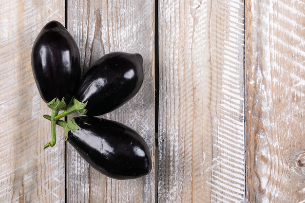 Free photo 3 eggplants on a wooden . flat lay. space for text