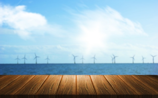 Free photo 3d background of a wooden table looking out to a wind farm in the sea