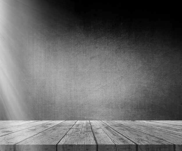 3D wooden table against grunge wall with light shining from the left