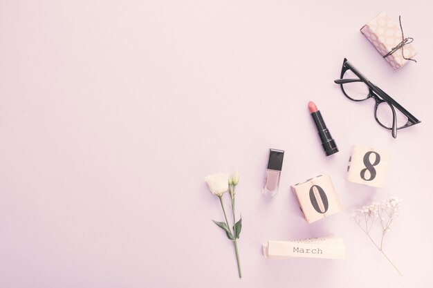 8 March inscription with flowers and cosmetics on table