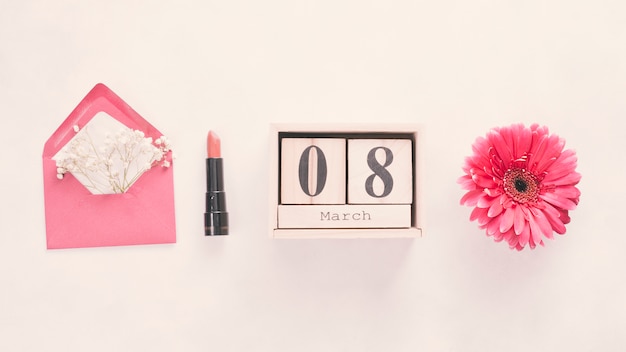 8 March inscription on wooden blocks with flower and lipstick