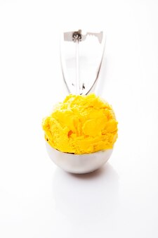Шарик натурального мороженого манго в ложке.