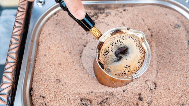 無料写真 トルコのイスタンブールで砂の上でコーヒーを作るバリスタ