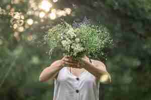 무료 사진 숲에서 소녀의 손에 야생 꽃의 꽃다발.