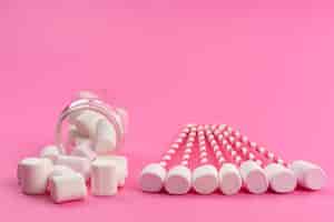 Бесплатное фото Вид спереди маленькие белые, зефир с палочками и внутри банка на розовых, сладких кондитерских конфетах