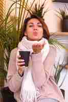 Бесплатное фото Девушка в уютном кафе согревается за чашкой горячего кофе