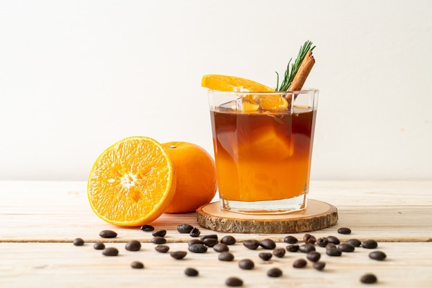 아이스 아메리카노 블랙 커피 한잔과 로즈마리와 계피로 장식 된 오렌지와 레몬 주스 층
